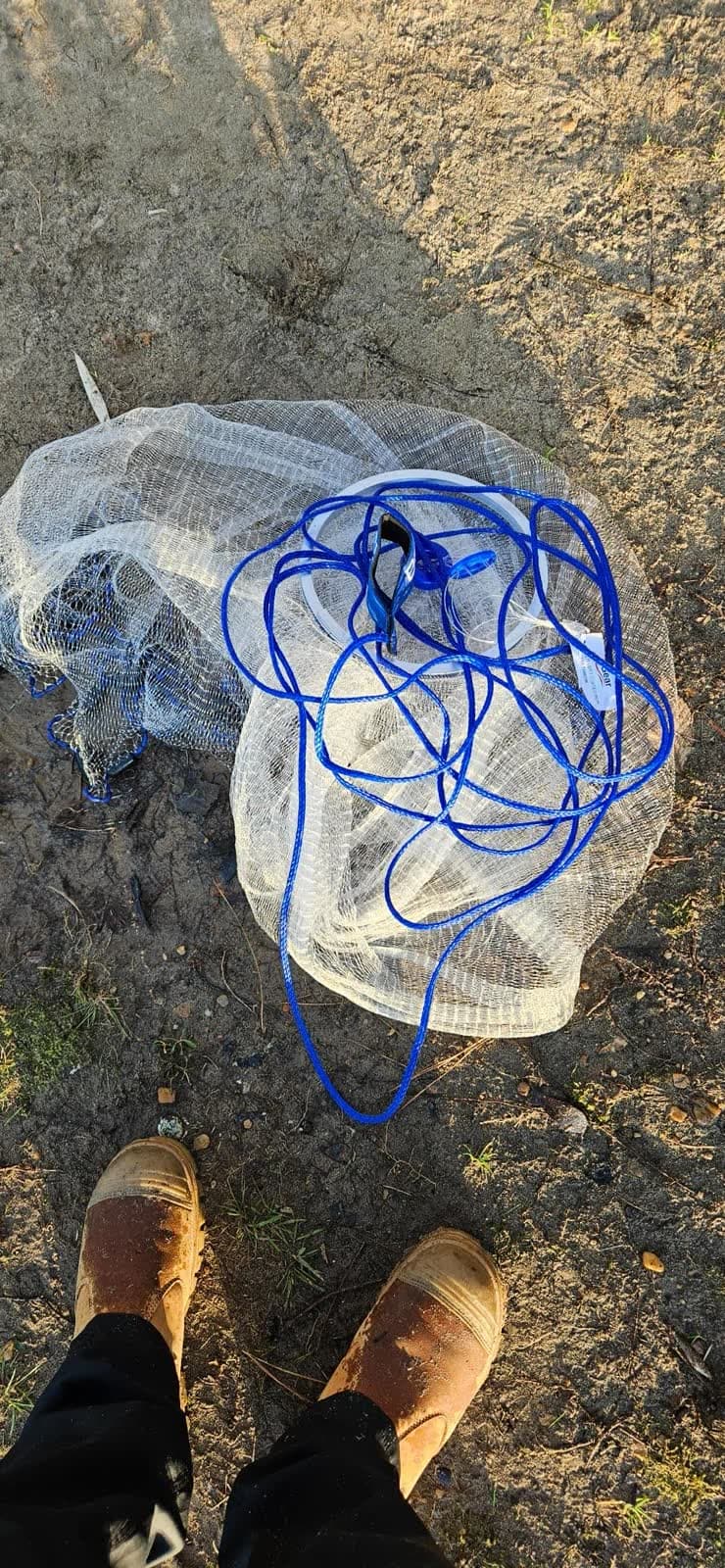 A customer's-eye view of their cast net bundled on the grass