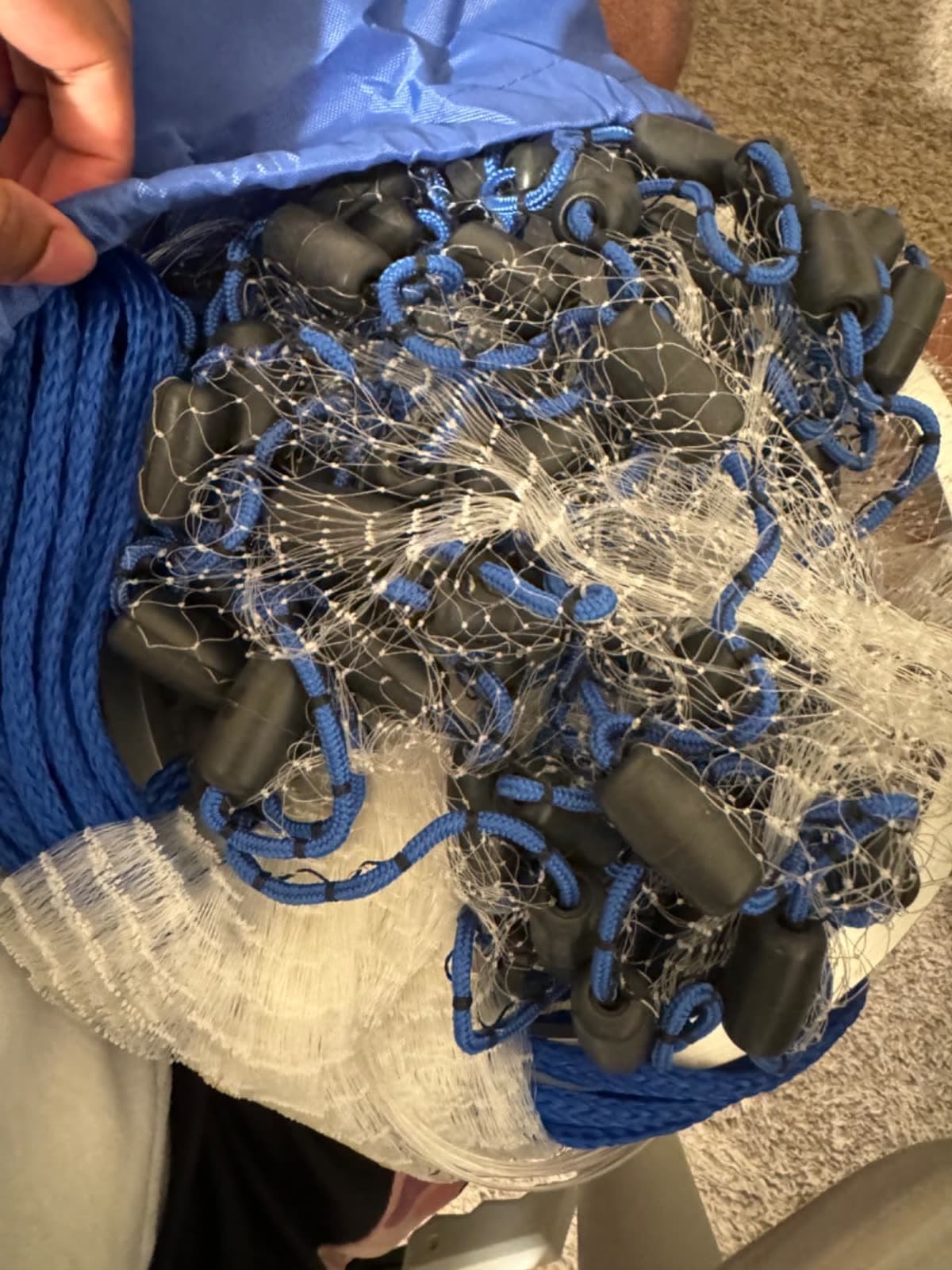 A customer holds their Easy Throw cast net, sinkers and blue rope visible
